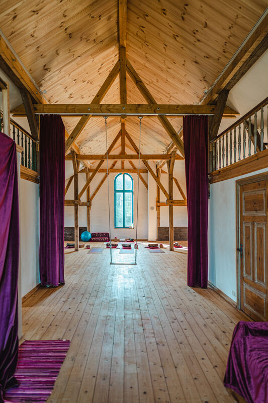 Blick durch den Saal mit Galerie und Vorhängen