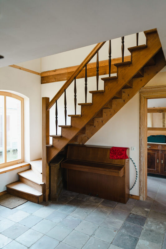 Holztreppe und Klavier im Treppenhaus